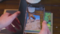 Phone camera scanning a photo album page to play an augmented reality video memory overlaid on the page